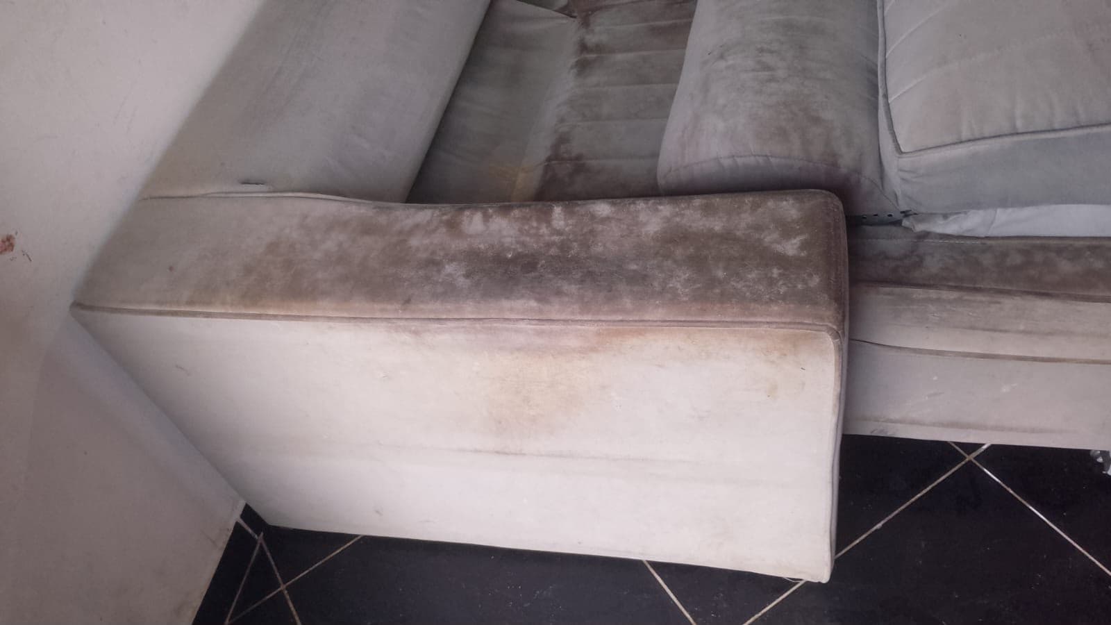 Sofá branco com o braço encardido pelo uso, antes do atendimento
